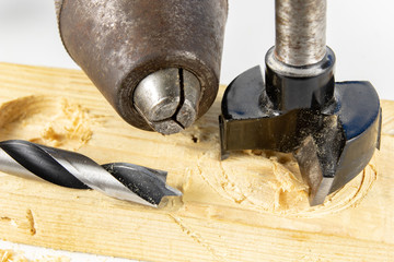 Drilling holes with a wood drill in a workshop. Joinery works performed with the use of cutting tools.