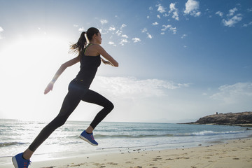 Young sport woman running in the morning on the beach.