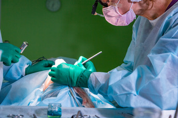 Surgeon and his assistant performing cosmetic surgery on nose in hospital operating room. Nose...