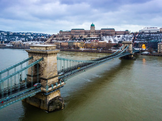 Fototapeta premium Budapest, Hungary - The beautiful Szechenyi Chain Bridge with Buda Castle Royal Palace at background on a cloudy winter day