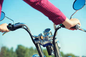 Girl biker riding a motorbike on an asphalt road.	