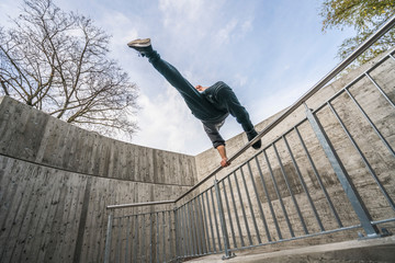 Parkour and freerunning jump over rail in the city