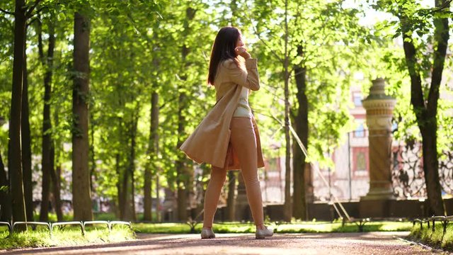 Happy business woman in trench coat dance and jump in street