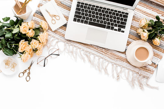 Female workspace with laptop, roses flowers bouquet, golden accessories, diary, computer, glasses on white background. Flat lay women's office desk. Top view feminine background.