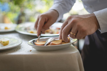 Obraz na płótnie Canvas a waiter prepares dishes on the restaurant table. Detail on cutlery