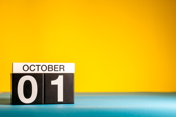October 1st. Day 1 of month, wooden color calendar on orange background. Autumn time. Empty space...
