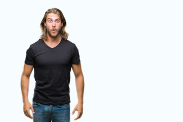 Obraz premium Young handsome man with long hair over isolated background afraid and shocked with surprise expression, fear and excited face.