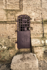 Cella di isolamento di una prigione, con inferriata e porta in ferro
