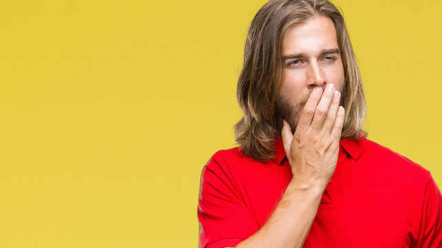Young handsome man with long hair over isolated background bored yawning tired covering mouth with hand. Restless and sleepiness.