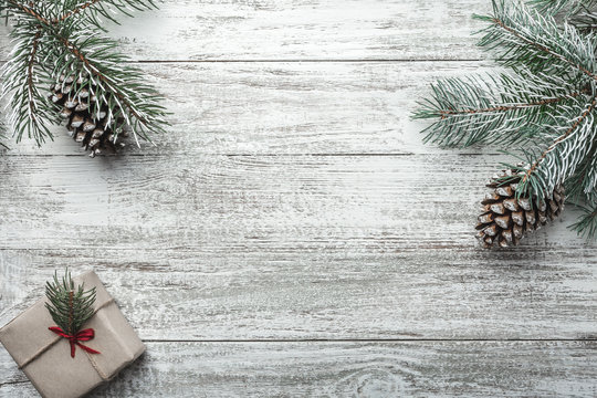 Christmas background with gift box and fir branches on old wooden table. Holidays background. Space for text