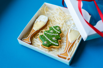 Christmas New Year holiday background, campagne glasses and christmas tree gingerbread packed in box on blue background.