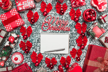 Circle of red bows and tree globes, balls with pen and pencil inside for text writing, and handmade decorative toys, present boxes, , on stone, marble background, Xmas greeting card