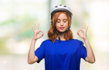 Young beautiful woman wearing cyclist helmet over isolated background relax and smiling with eyes closed doing meditation gesture with fingers. Yoga concept.