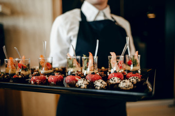 Professional waiter. Joyful nice man holding food whole working as a waiter in the cafeteria 