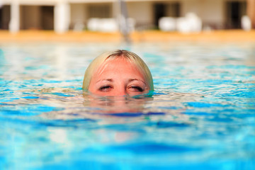 girl in pool. head half in water