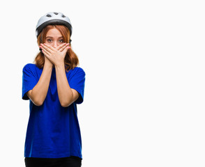 Young beautiful woman wearing cyclist helmet over isolated background shocked covering mouth with hands for mistake. Secret concept.