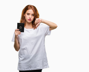 Fototapeta premium Young beautiful woman holding passport of united states of america over isolated background with angry face, negative sign showing dislike with thumbs down, rejection concept