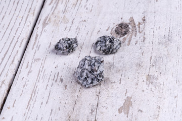 Steine mit Perlen auf weißem antiken Holz als Hintergrund