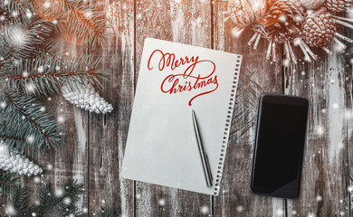 Old wood background, green fir tree with white cones, a cone basket, Merry Christmas message and...