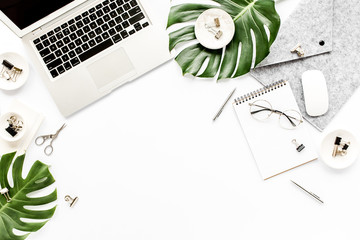 Home office workspace mockup with laptop, tropical leaves Monstera, clipboard, notebook and...