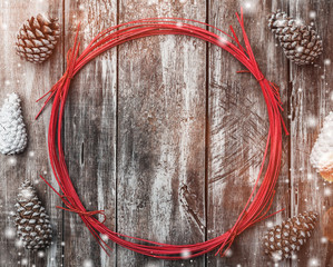 Old wood background, fir cones around a red circle. Holiday space for winter, xmas, New Year and...