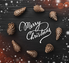 Black wooden background with the texture highlighted with golden cones in the shape of a circle on...