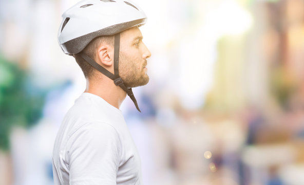 Young Handsome Man Wearing Cyclist Safety Helmet Over Isolated Background Looking To Side, Relax Profile Pose With Natural Face With Confident Smile.