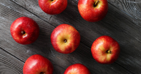 From above shot of few ripe shiny apples with red peel composed in circle on gray wooden table