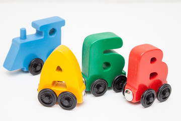Obraz premium Russian wooden letters train alphabet with locomotive. Bright colors of red yellow green and blue on a white background. Early childhood education, learning to read, preschool and kids game concept.