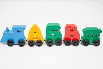 Fototapeta premium Russian wooden letters train alphabet with locomotive. Bright colors of red yellow green and blue on a white background. Early childhood education, learning to read, preschool and kids game concept.