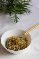 Korean food, soy sprount marinated with garlic and soy sauce with chopstick, selective focus, vertical