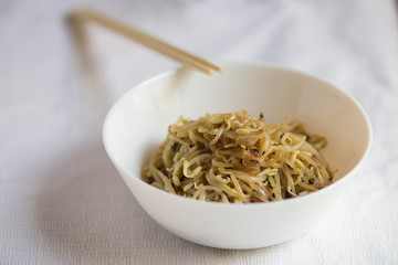 Korean food, soy sprount marinated with garlic and soy sauce with chopstick, selective focus, close up