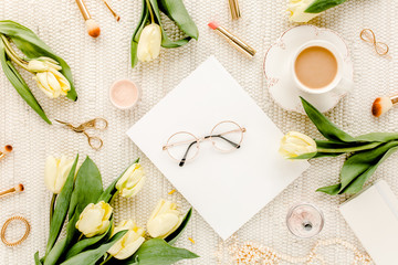 Fototapeta na wymiar Female workspace with yellow tulip flowers, women's fashion golden accessories, diary, glasses on white background. Flat lay. Top view feminine background.