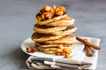 Stack of delicious sweet and spicy apple pancakes with fried caramelized apples, anise, cinnamon...