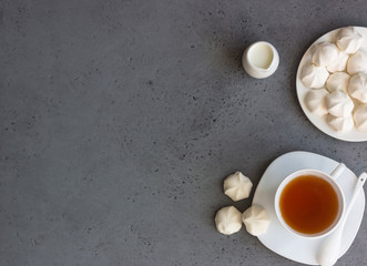 A cup of black tea with white mini marshmallow (homemade white zephyr). Copy space