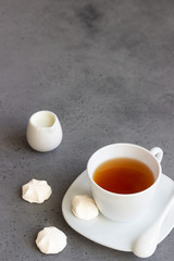 Obraz na płótnie Canvas A cup of black tea with white mini marshmallow (homemade white zephyr). Copy space