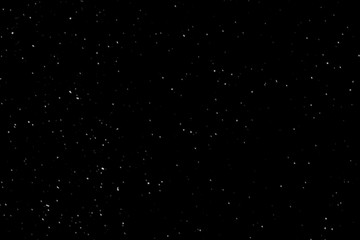 Falling down real white snowflakes on black background. Isolated snowfall calm snow minimalistic design element. Snowstorm texture. Bokeh lights on black background, shot of flying snowflakes in air