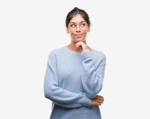 Young beautiful hispanic woman wearing a bun serious face thinking about question, very confused...
