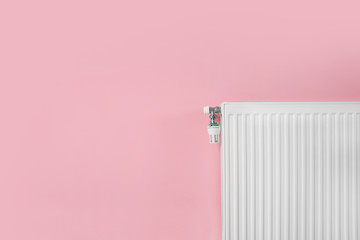 Heating radiator with thermostat near color wall. Space for text