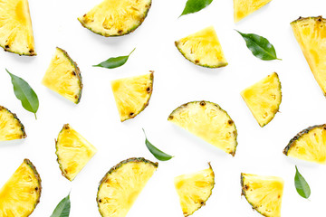 Naklejka premium Slices pineapple with green leaves isolated on white background. Flat lay, top view