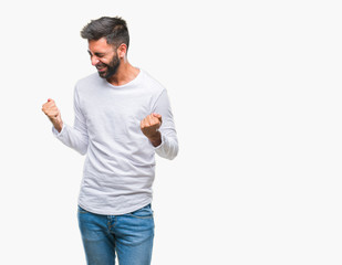 Adult hispanic man over isolated background very happy and excited doing winner gesture with arms raised, smiling and screaming for success. Celebration concept.