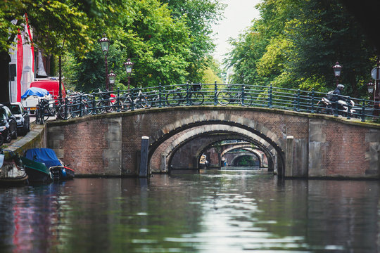 City view of Amsterdam canals with bridges and bicycles, Netherlands