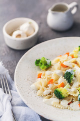 Homemade farfalle with with broccoli and carrots, bechamel