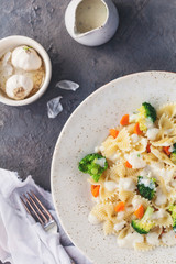 Homemade farfalle with with broccoli and carrots, bechamel