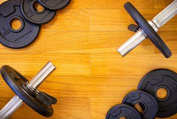 Dumbell Bars and Weights on Wooden Background
