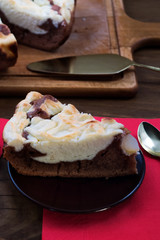 A piece of cake made of chocolate dough with cottage cheese, laid on a dessert plate.