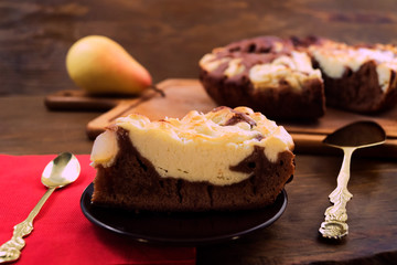 Piece of cake on dessert plate, spoon and cake spatula, wooden background.