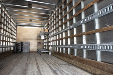 Inside an industrial shipping truck's cabin empty with a few things and crates mtal and wood