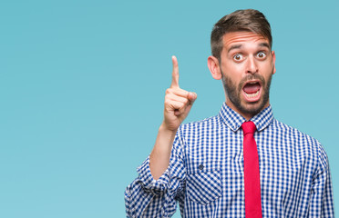 Young handsome business man over isolated background pointing finger up with successful idea. Exited and happy. Number one.