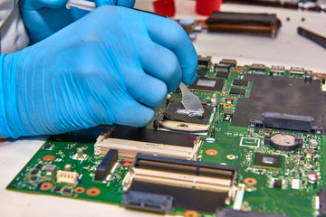 Hands of the technician repairing a computer, Technician who changes the computer's processor,...